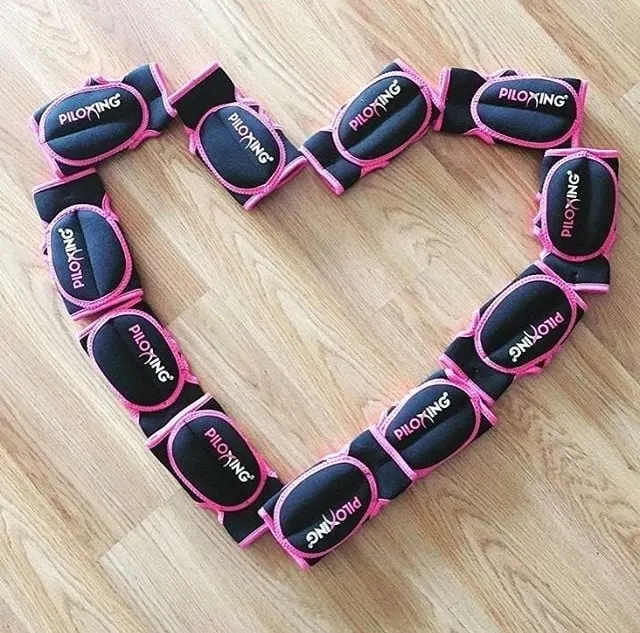 Des gants de Piloxing® disposés en forme de cœur sur un parquet