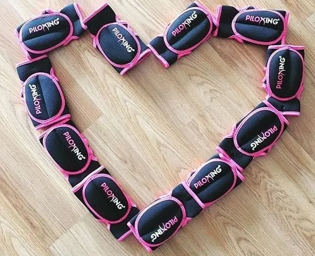 Des gants de Piloxing® disposés en forme de cœur sur un parquet