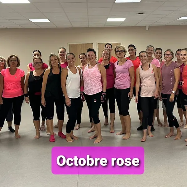 Photo de groupe en tenues roses, pieds nus, avec l’inscription « Octobre rose »