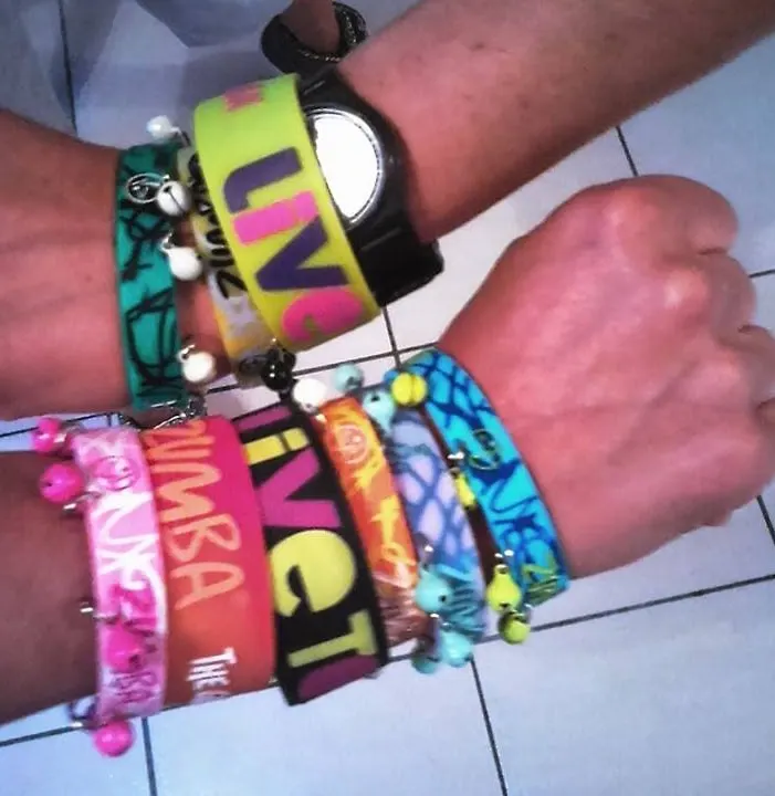 Deux poignets couverts de bracelets colorés, dont un bracelet Zumba®
