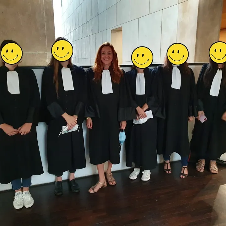 Six personnes en robe noire à rabat blanc, visages cachés par des émoticônes sauf un