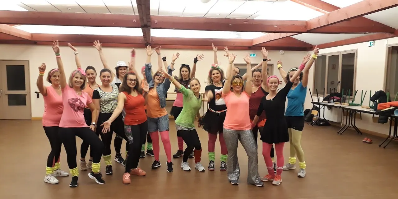 Groupe en tenues fluo des années 80, jambières et bandeaux, bras levés
